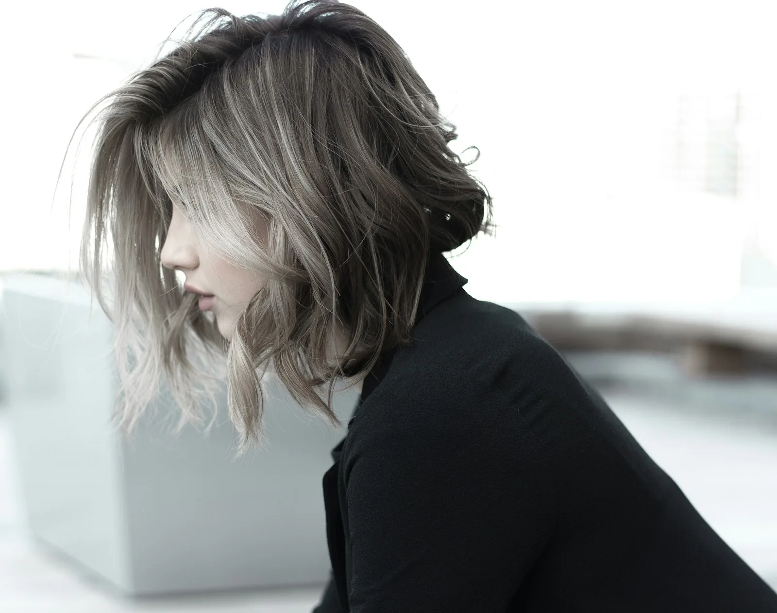 A smoky ash-blonde bob in profile, dimensional from root to tip.